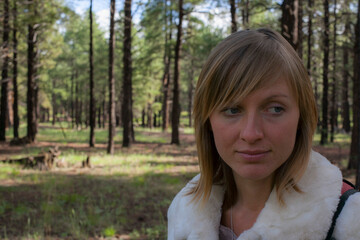 A pensive young woman outdoors in the forest