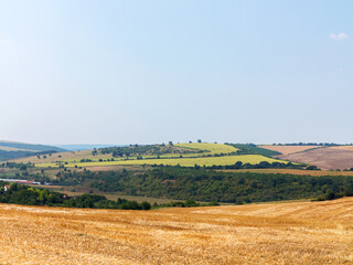 Obraz premium mown field on a bright autumn day. Collect grain harvest. Farming, idyll landscape background