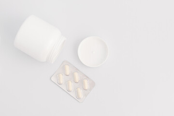 Jar with pills and a blister on a white background. Flat lay.