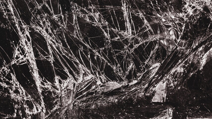 broken cracked glass with big hole over dark background
