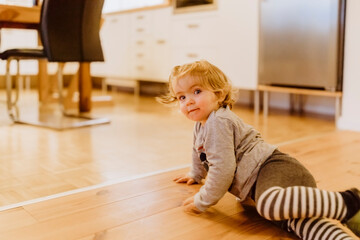 Toddler playing on floor in kitchen