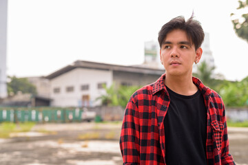 Fototapeta premium Young handsome Asian hipster man in the city streets outdoors