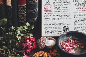 Wiccan witch altar with an open book of shadows with hand written spell in it, ready for spell...