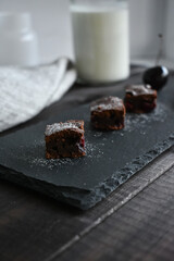 chocolate brownie with cherry on a stone plate