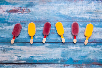 Ice cream stick placed on a blue vintage wooden background