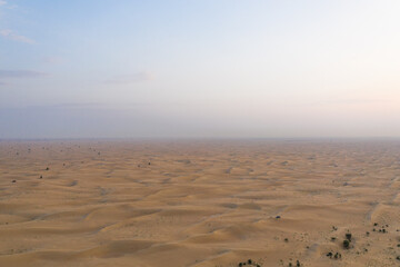 Sand dunes textures in endless desert during sunrise