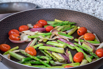 stir frying fresh vegetables in a pan closeup