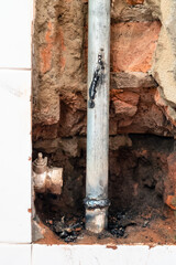 repairing of plumbing riser of heated towel rail at home - piece of new pipe welded into water pipe when disconnecting valve in wall of bathroom