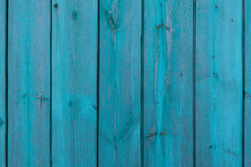 Wooden old vintage fence painted with turquoise paint. Abstract background made of texture boards.