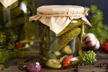Pickled cucumbers with dill and garlic in a glass jar.