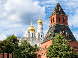 view of Kremlin Wall with Taynitskaya Tower and Cathedral of the Archangel and Ivan the Great Bell Tower during city sightseeing tour on excursion bus in Moscow city on summer day