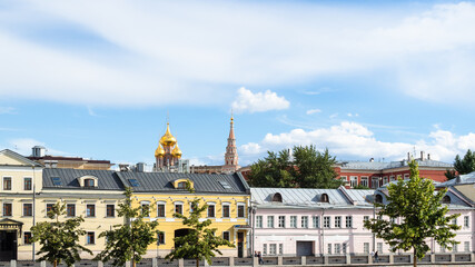panoramic view of urban houses on Kadashevskaya embankment and golden cupola of Resurrection Church in Kadashi Sloboda during city sightseeing tour on excursion bus in Moscow city on sunny summer day