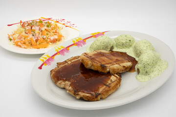 dish made with pork with sauce, dressed baked potatoes and salad