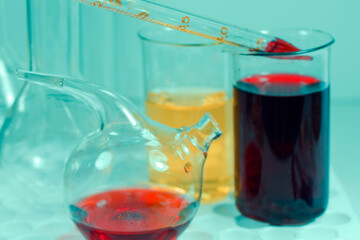 Laboratory chemical liquid elements and research diagnoses, instruments and objects in the sterile table, glassware and pipette.