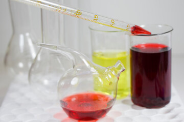 Laboratory chemical liquid elements and research diagnoses, instruments and objects in the sterile table, glassware and pipette.