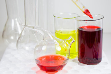 Laboratory chemical liquid elements and research diagnoses, instruments and objects in the sterile table, glassware and pipette.