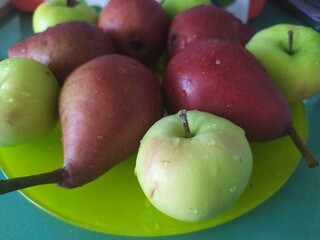 Food stilllife fruits apples pears on a yellow plate cookies and sweets on the kitchen table