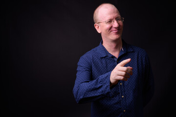 Portrait of happy bald businessman with eyeglasses