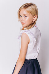 Back to school. Cute adorable caucasian blondie girl in school uniform on white background