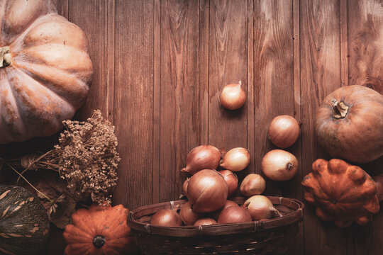 autumn pumpkins and other fruits and vegetables on a wooden table, top view