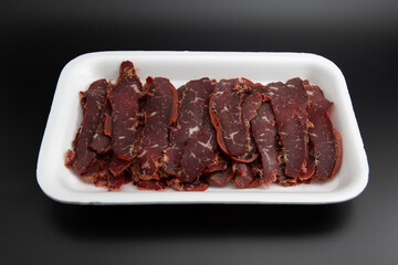 Raw lamb chops (cutlets) in a white styrofoam box isolated on black background with copy space for text