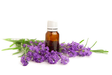A bottle with essential oil and a bouquet of lavender on a white isolated background.