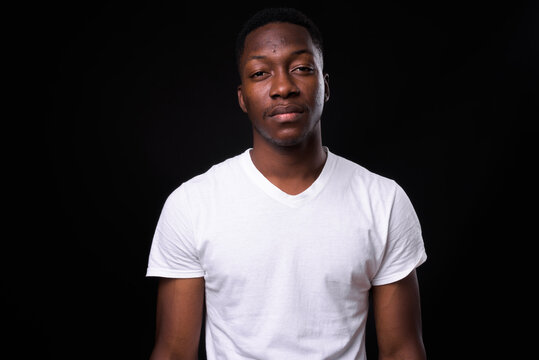 Young handsome African man against black background