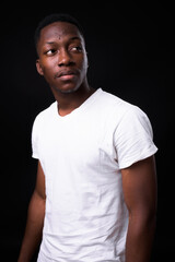 Young handsome African man against black background