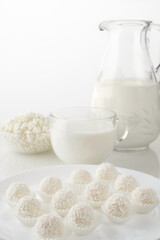Breakfast of sweets, cottage cheese and milk on a white mirror table