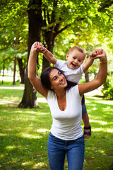 Fototapeta premium young pretty brunette mother with little cute boy walking in park happy smiling, lifestyle people concept