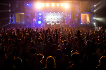Fototapeta na wymiar People with raised hands on open air disco concert