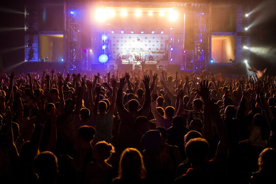 People with raised hands on open air disco concert