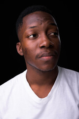 Obraz premium Young handsome African man against black background