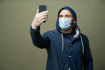 Fototapeta na wymiar doctor talking on the phone. A man in a protective blue raincoat is holding a phone. I put a protective mask against the virus on my face.