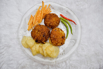 Delicious home cooked Sabudana or Sago vada a popular deep fried traditional snack from India. Potato wafers and alu potato faradi sticks