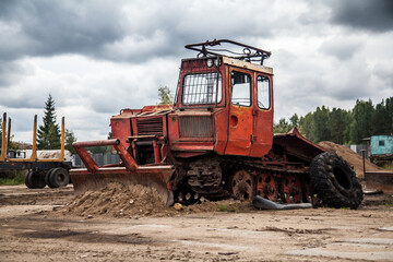 Fototapeta na wymiar Old Soviet tractor on dirty road