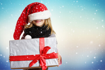 kind mit Geschenk und Weihnachtsmütze