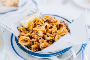Fried squid on a plate in a restaurant. Typical recipe from Spain. 