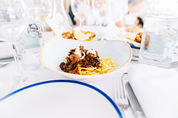 Elegant white table of a restaurant with food dishes.