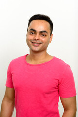 Portrait of happy young handsome Indian man smiling