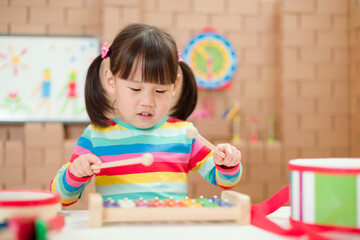 Fototapeta premium young girl play xylophone at home for homeschooling