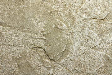 Golden messy wall stucco texture. Closeup decorative plaster paint.