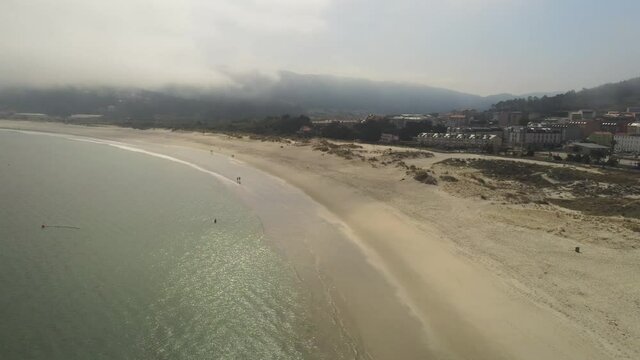 Beach wih fog in coastal village. Galicia,Spain. Aerial Drone Footage