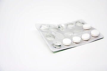 A used blister pack with some missing pills isolated on a white background. Medicine and pharmaceutical products.