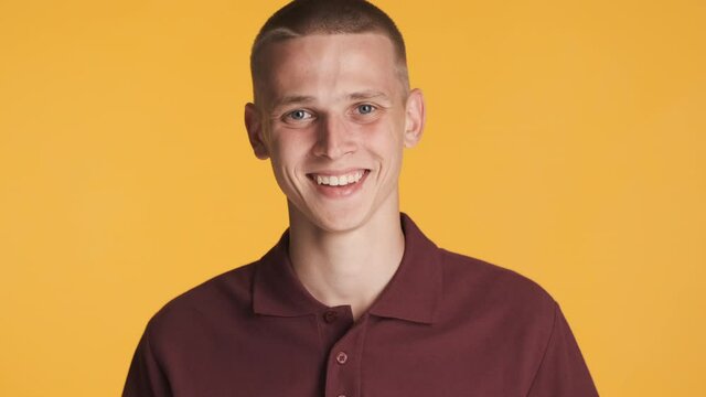 Attractive positive guy happily laughing on camera over colorful background