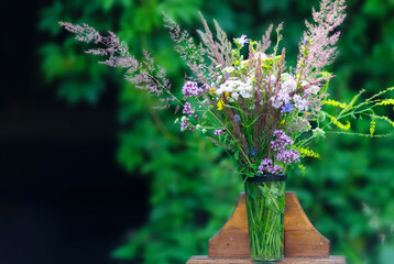 Bouquet of wild flowers in vase in a garden