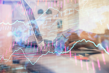 Double exposure of woman hands typing on computer and forex chart hologram drawing. Stock market invest concept.