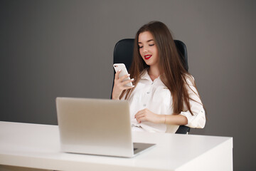 Business concept - brunette businesswoman talking on the phone in the office,