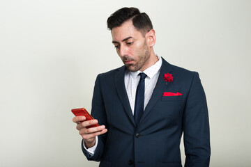 Portrait of handsome bearded businessman using phone