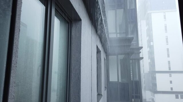 Heavy rain outside the open window. view of the facade of a modern building on a rainy day